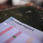 Laporan revenue perusahaan dengan grafik batang di atas meja kantor